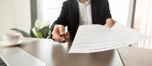 Landlord offering a lease agreement and pen to sign, symbolizing key elements to include in a Texas rental contract.