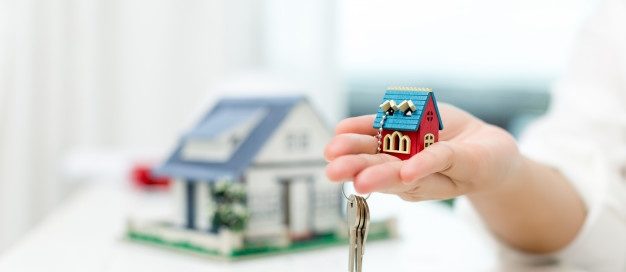 Landlord holding a small model house and keys, representing the Texas eviction notice and legal eviction process for tenants.