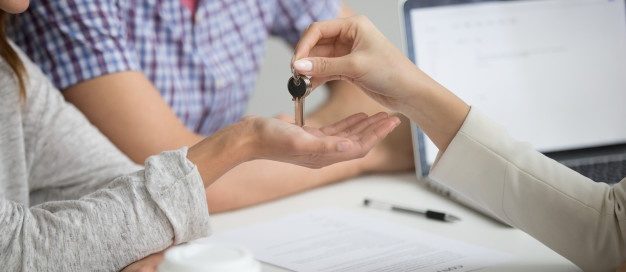Landlord handing over keys to smiling tenants after issuing a notice to vacate, representing the Texas rental and eviction process.