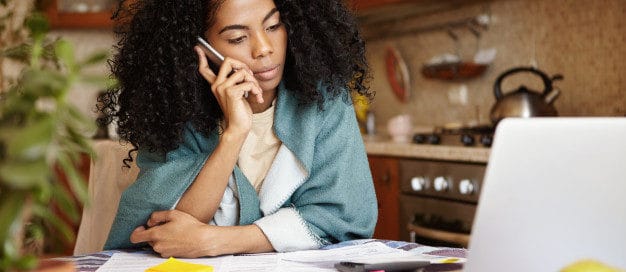 Concerned landlord speaking on the phone while reviewing tenant eviction documents at home, representing Texas landlord eviction process.