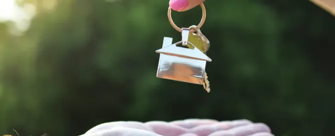 Hand holding a key with a small house keychain, symbolizing the Texas eviction process and landlord-tenant law.