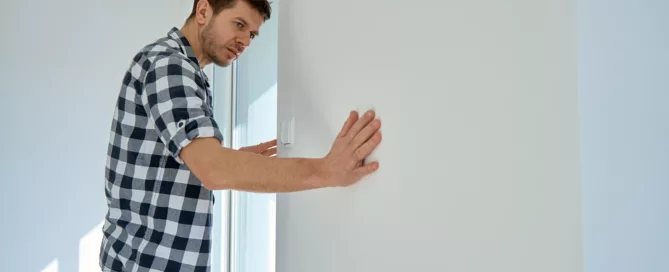 Man inspecting property damage on wall in Dallas Fort Worth rental